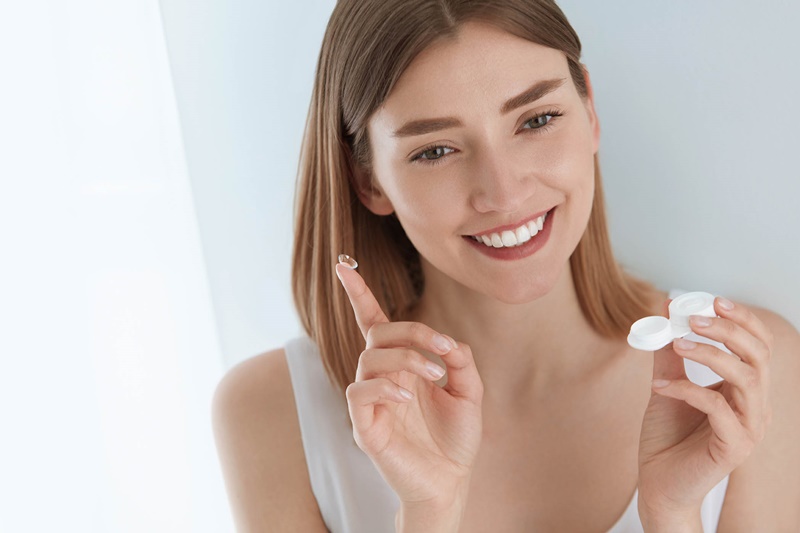 uma jovem se adaptando as lentes de contato